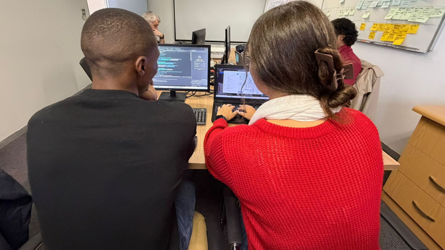 Two colleagues working together at a computer screen